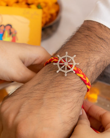 Handcrafted Silver Wheel Rakhi with Red & Yellow Moli Thread – Aneytri