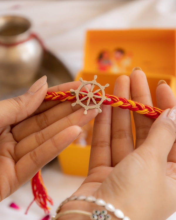 Handcrafted Silver Wheel Rakhi with Red & Yellow Moli Thread – Aneytri