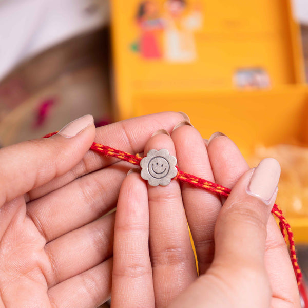 Smiley Face Flower Rakhi in 92.5 Silver with Red Moli Thread – Cute Raksha Bandhan Kids Design