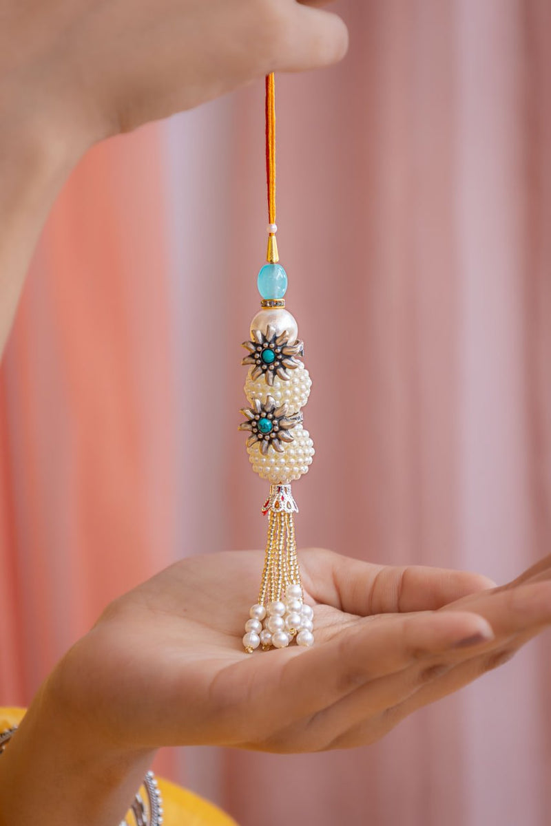 Elegant Pearl Latkan Rakhi with Silver Floral Accents and Tassels – Aneytri